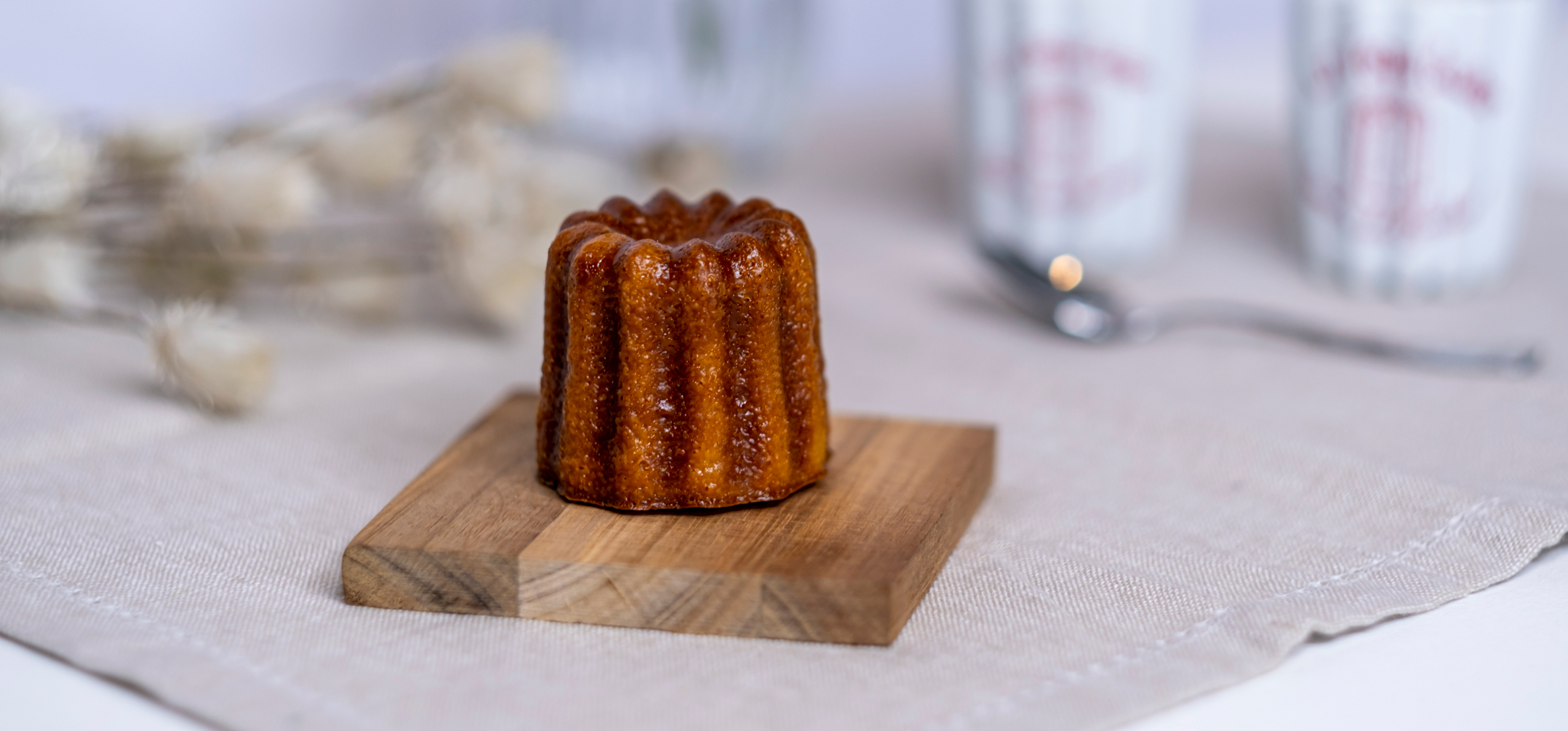 Canelé pastry on a wooden board, showcasing its caramelized crust and fluted edges